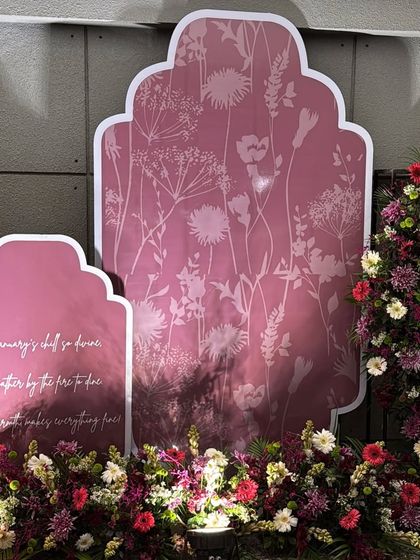 A custom designed backdrop for the Lohri party. The pink panels feature a subtle floral silhouette pattern and a sweet poem about the festival, adding a personal and artistic touch.