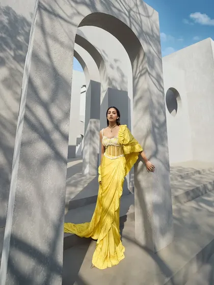 A stunning ruffle corset sari in a vibrant yellow, with pearl embellishments on the corset adding a touch of elegance. A look that’s effortlessly chic yet timeless.