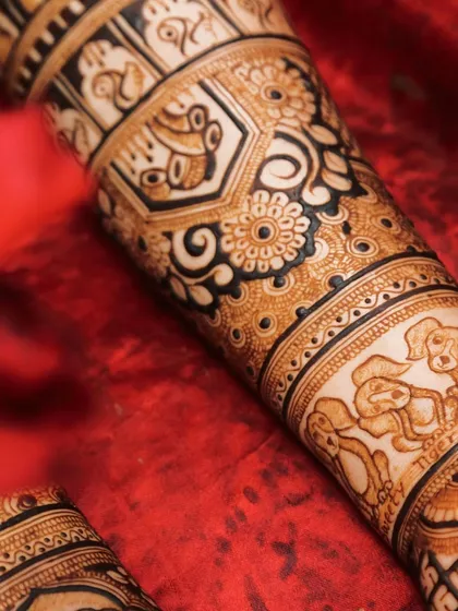 Your pets are family, and I love including them in your bridal henna. This is a close-up of a custom design featuring portraits of the bride's beloved dogs, a truly personal touch.