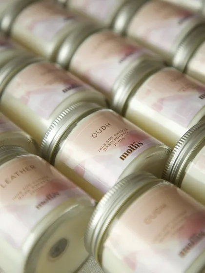 A close-up of the 'Oudh' scented candles for the baby announcement.