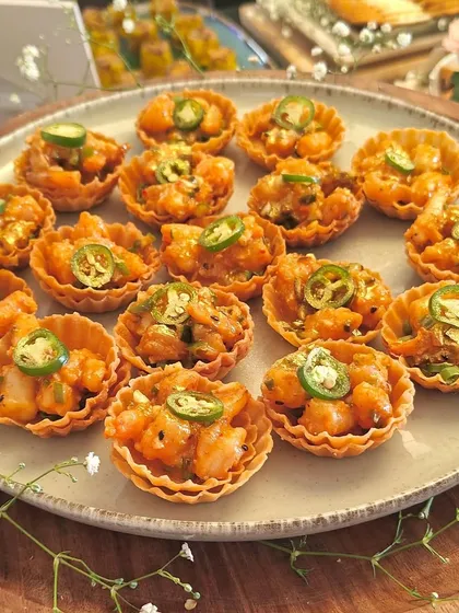 A platter of our spicy water chestnut tarts, topped with jalapeños. These bite-sized tarts offer a delightful crunch and a kick of flavor.
