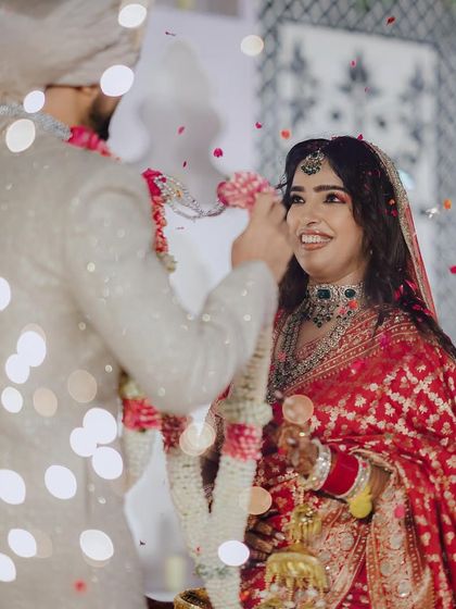 The Varmala exchange, a moment of love and commitment, beautifully captured with soft lighting and a shower of petals. We stage these key moments to feel both intimate and magical.