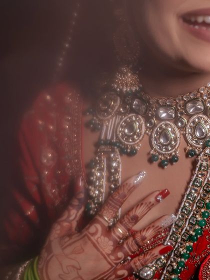 A soft-focus, artistic close-up of the bride's hands, mehndi, and stunning necklace. This shot is all about texture and detail.
