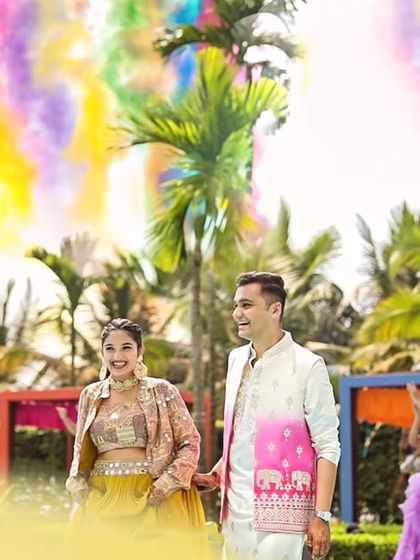 The couple's grand entrance to their Coachella Haldi, framed by colorful smoke effects against the palm trees. We love creating picture perfect moments that are full of energy and style.