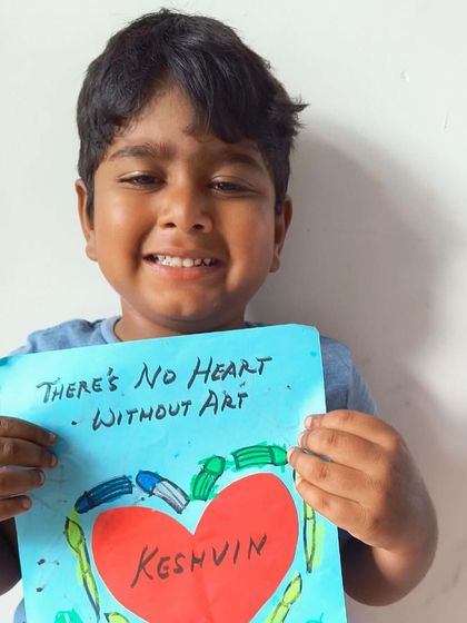 "There's No Heart Without Art." A young student holds up his heartfelt and colorful creation.