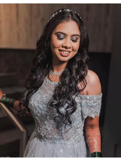 The princess glam. Shweta looks like a doll in her reception gown, with beautiful curls and a dramatic smokey eye.