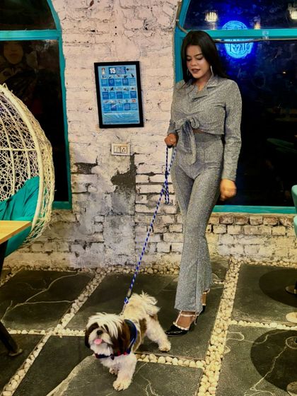 Another angle of our stylish guest and her pup. Our cafe's rustic white brick wall is a popular photo spot.