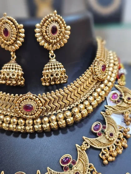 The matching jhumka earrings and the detailed choker complete this stunning traditional bridal set.