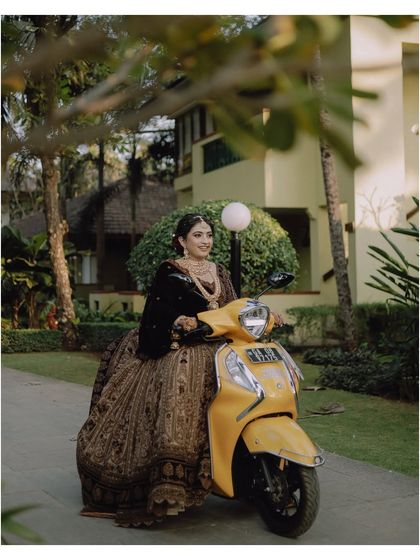 A fun and quirky bridal portrait, with the bride posing on a bright yellow scooter. We love it when our brides show their playful side!