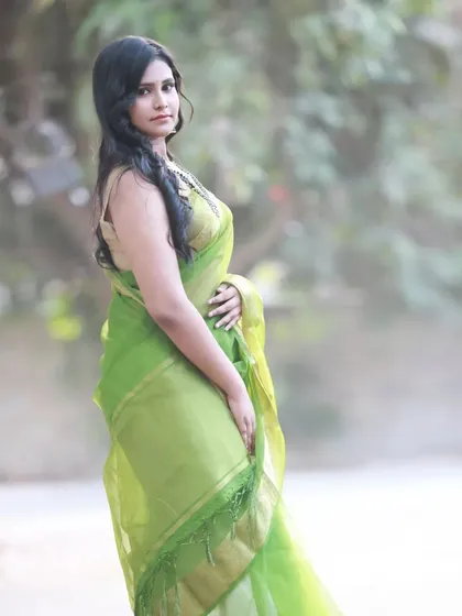 A simple and elegant outdoor portrait in a light green organza saree. The soft, natural light and blurred background make the model and the saree the main focus.