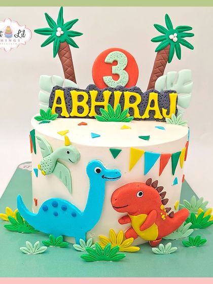 A colorful and friendly dinosaur cake for a 3rd birthday. This design features cute, cartoon-style dinosaurs and tropical palm trees.