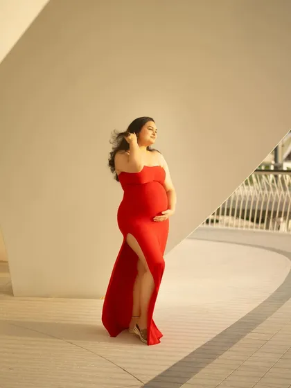 The wind in her hair, the sun on her skin. This candid outdoor shot captures a feeling of freedom and radiant confidence, with the modern architecture providing a striking contrast.