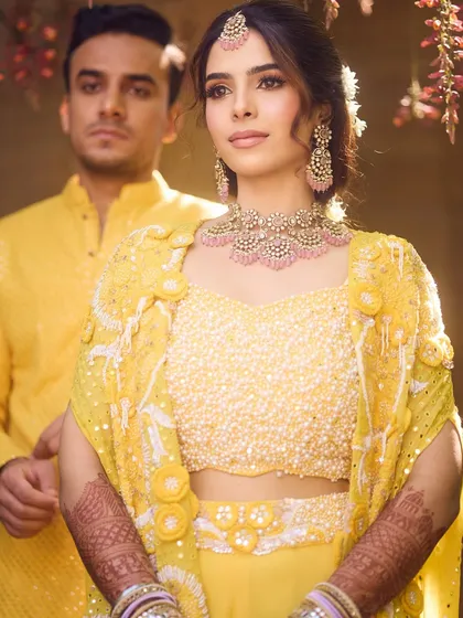 A portrait of the couple. Her soft and glowing Haldi look is a beautiful complement to the festive atmosphere.