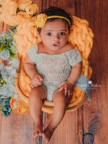 An overhead shot that captures the entire beautiful setup. The wooden floor, colorful flowers, and cozy basket create a warm and inviting scene.