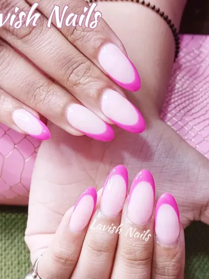 A vibrant and bold French manicure with bright pink tips on long, almond-shaped nails.