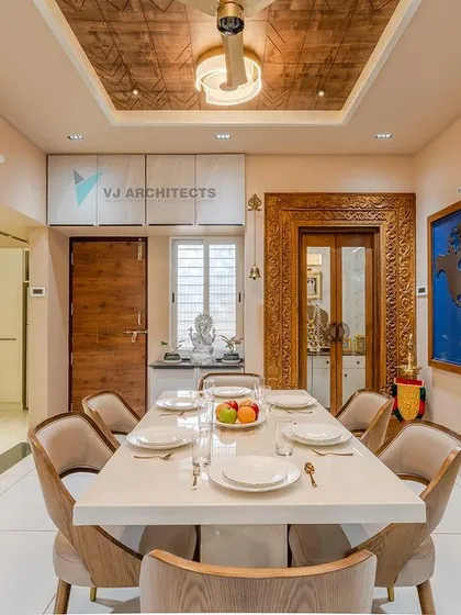 We designed this dining space for a travel-loving couple, fusing their passion with our design. The centerpiece is a custom wooden world map, complemented by a contemporary dining set and a carved doorframe that adds a touch of traditional South Indian craftsmanship.