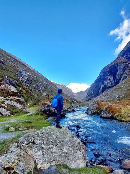 A trekker taking in the magnificent view of the river valley during the Hampta Pass trek.