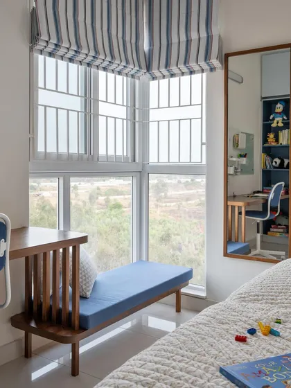 For this kid's bedroom, we incorporated a window seat next to the study desk. It serves as a versatile play deck and a lounge spot, positioned at a comfortable height for a growing child.
