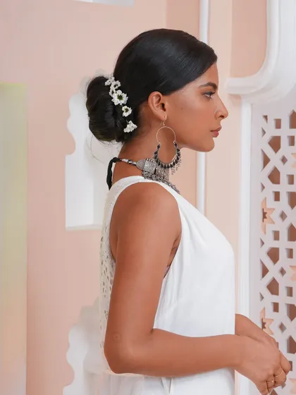 A side profile of a classic low bun, perfect for a reception or engagement look. The added volume from our extensions ensures the bun is full and perfectly shaped.