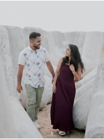Walking hand-in-hand through the unique landscape of sea-break tetrapods. This location offers a modern, geometric contrast to the natural beach setting.
