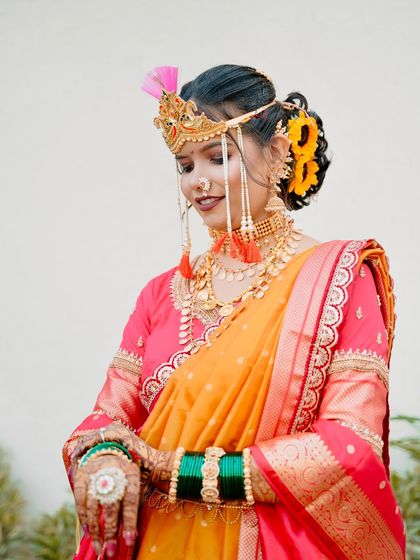 A close up of the bride's face, showing the traditional headgear and the delicate details of her makeup.