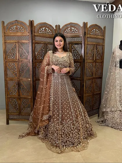 Not all brides wear red, and this magnificent pre-loved bridal lehenga proves why. The rich brown fabric is covered in dense, shimmering gold floral embroidery, creating a truly grand and unforgettable look.