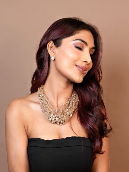 Elegance with a splash of crimson. The client's hair colour provides a stunning contrast against a simple black dress, making it the centerpiece of her look.