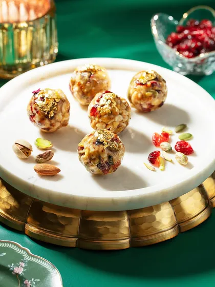 These dry fruit and nut laddoos are presented on a beautiful marble and brass cake stand. The rich green background and festive lighting create an elegant and celebratory image for Marriott's Diwali campaign.