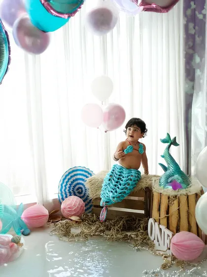 A magical mermaid-themed first birthday. We create an underwater wonderland in our studio with custom props, a knitted mermaid tail, and pastel balloons for a truly enchanting celebration.