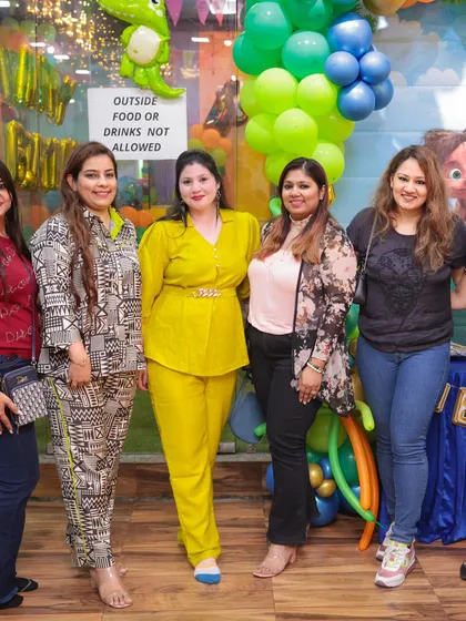Parents and guests enjoying the celebration at a dinosaur-themed birthday bash. We ensure everyone has a great time.