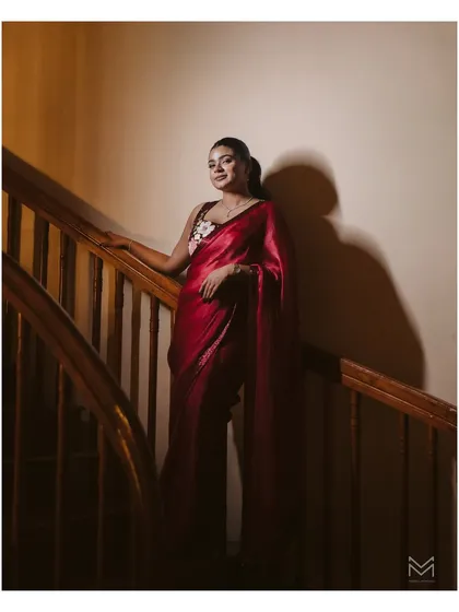 Samerah's elegance is captured in this beautifully lit portrait on a wooden staircase. The dramatic lighting and her graceful pose create a timeless and artistic image from her engagement shoot.