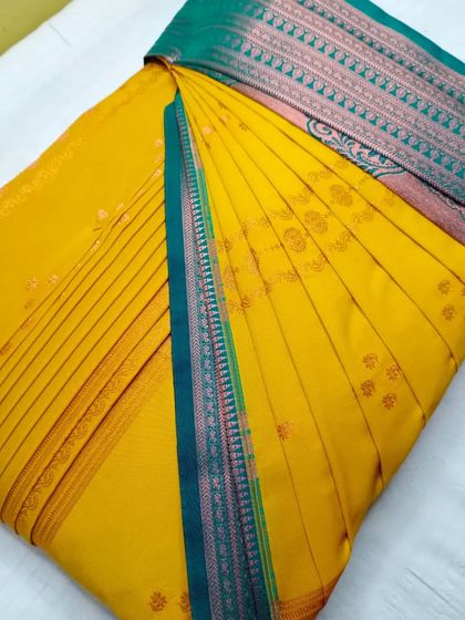 A bright yellow saree with a teal and pink border. The pleats are crisp and the saree is ready to be draped in minutes.