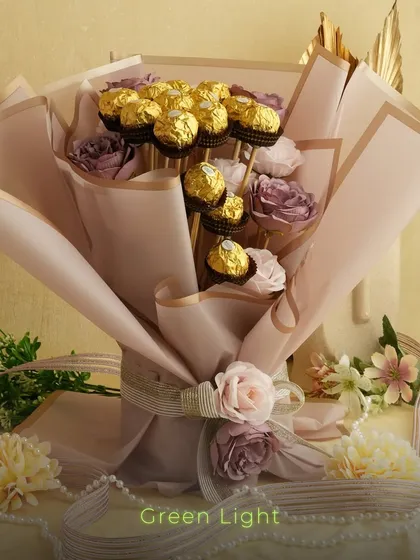 Another view of the stunning Ferrero Rocher and rose bouquet, showing the detail in the wrapping and arrangement. It's a perfect gift for any romantic occasion.
