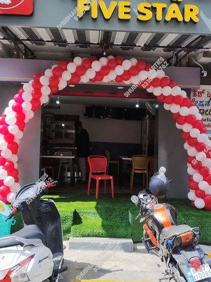 A red and white spiral balloon arch for the grand opening of a "Five Star" chicken store.