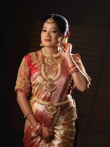 The bride adjusting her jhumka, giving a glimpse of the matching earrings that come with this rental antique set.
