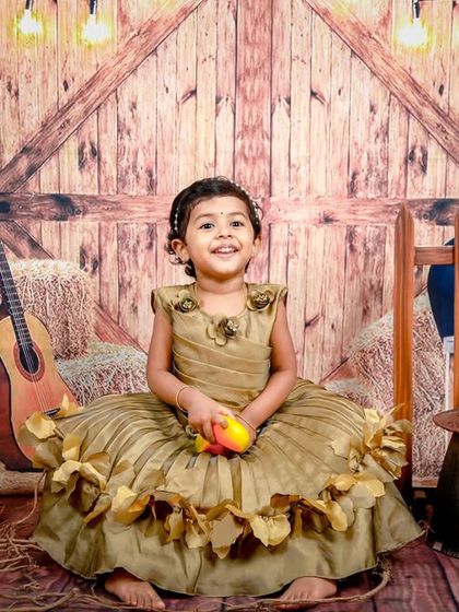 A happy little cowgirl enjoying our rustic barnyard setup. The warm lighting and wooden textures create a cozy and inviting atmosphere.