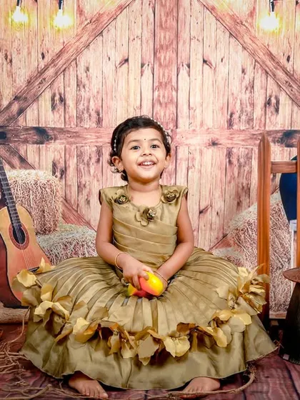 A happy little cowgirl enjoying our rustic barnyard setup. The warm lighting and wooden textures create a cozy and inviting atmosphere.