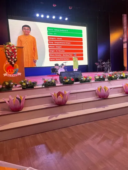 A student's performance projected on the big screen at the school competition. We celebrate the courage and skill it takes to perform on a big stage.
