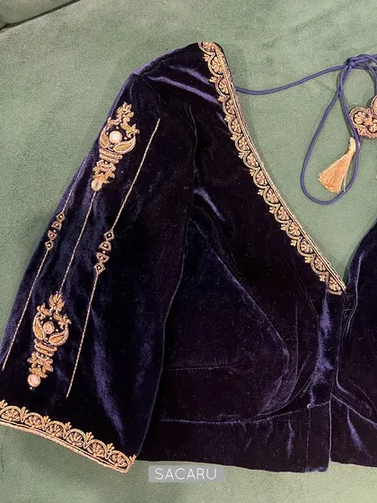 The front view of the sapphire blue velvet blouse, featuring a deep V-neck and elegant tassels.