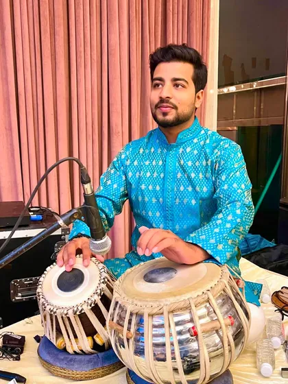 A candid shot from a private mehfil, dressed in a blue bandhani kurta.
