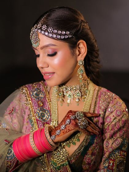 The way she holds her hand showcases the beautiful henna and the soft, elegant details of her bridal look.