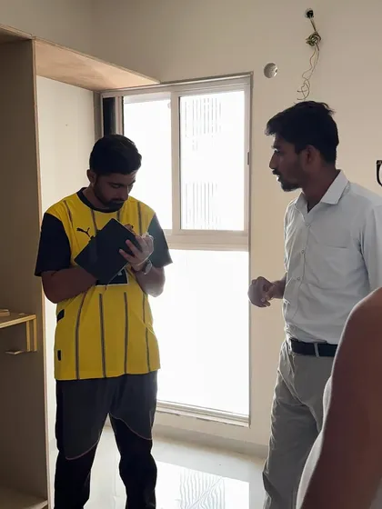 Reviewing plans on a tablet with a team member during the wardrobe installation phase.