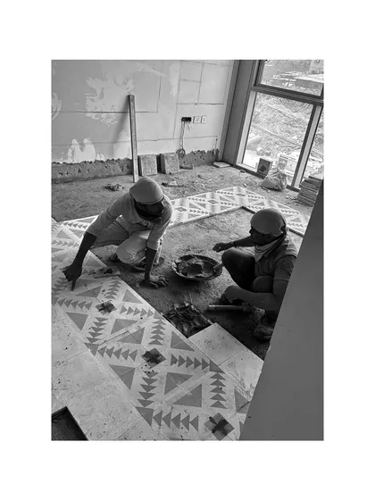 Our team carefully laying patterned cement tiles. The dust, hustle, and precision are the backbone of our completed projects.