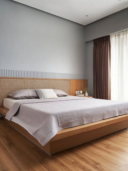 Named 'The Rattan Room', this bedroom is designed for ultimate relaxation with minimal furniture. The oak and rattan headboard is set against a fluted wall, creating a tranquil, warm space.