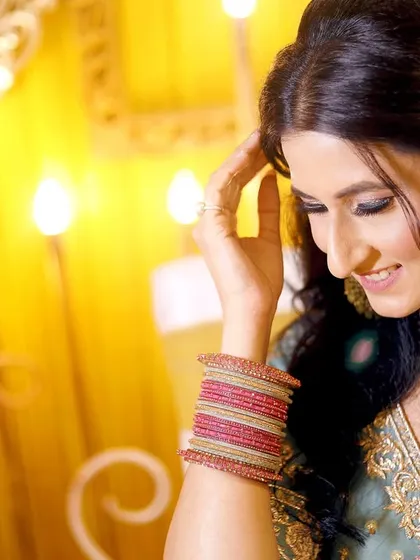 A candid, happy moment of the bride-to-be during her engagement ceremony. Her natural smile and the warm lighting create a beautiful portrait.