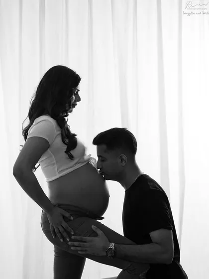 A classic pose of a partner kissing the belly. In black and white, this image becomes a powerful symbol of love for the new life you've created together.
