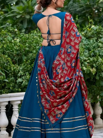 The back view of the elegant teal blue lehenga. The simple tie-up back and the way the dupatta is draped show off the beautiful print and the flow of the fabric.