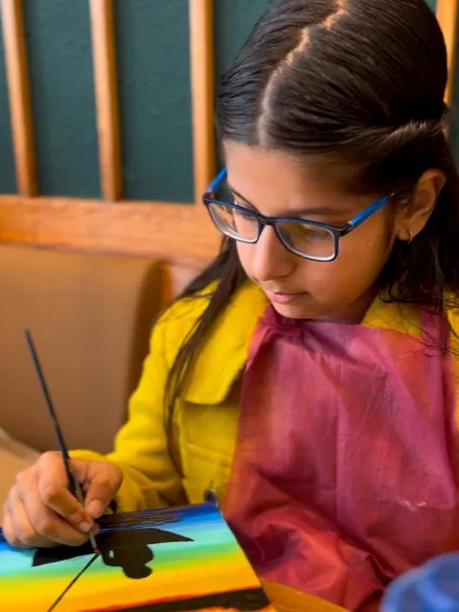 The focused expression of a young artist painting a sunset. It's amazing to see such concentration and passion at a young age.