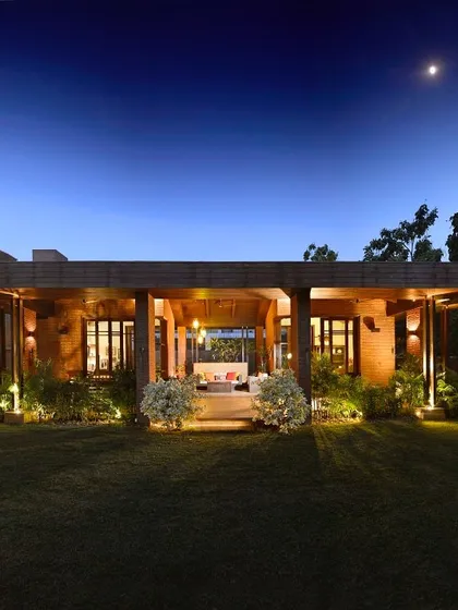 At night, the K Pavilion becomes a warm, inviting outdoor living room. The wooden structure is illuminated to highlight its form, creating a perfect space for evening relaxation that overlooks the garden.
