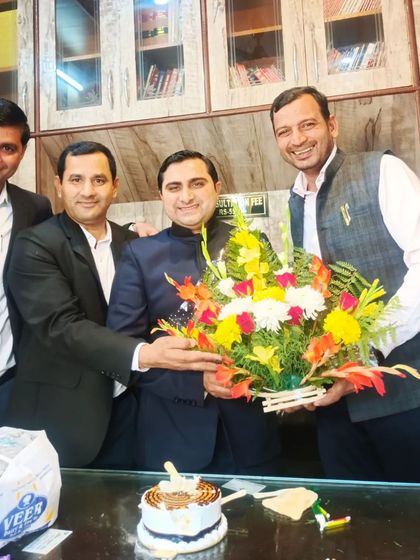 Celebrating a colleague's success with a bouquet and cake.